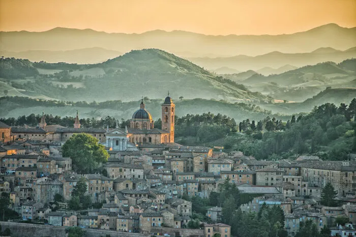 Auf einem Hügel sitzt Urbino, wie so viele andere Städte in der Region Marken. Dennoch ist der Ort anders – denn er ist architektonisch zu großen Teilen in der Renaissance stehen geblieben. Urbino erlebte im 15. Jahrhundert eine große kulturelle Blüte, zog Künstler und Wissenschaftler aus ganz Italien und darüber hinaus an. Im 16. Jahrhundert aber folgte eine Zeit der wirtschaftlichen und kulturellen Stagnation, weshalb die kleine Stadt ihren Zustand im Zentrum konserviert hat.