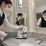An employee places facial masks in the bathroom of a suite of Berlin's famous Hotel Adlon Kempinski on May 26, 2020, one day after it reopened for tourism as restrictions were eased amid the novel coronavirus / COVID-19 pandemic. (Photo by Tobias SCHWARZ / AFP)