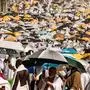 Muslim pilgrims use umbrellas to shade themselves from the sun as they arrive at the base of Mount Arafat, also known as Jabal al-Rahma or Mount of Mercy, during the annual hajj pilgrimage on June 15, 2024. Friends and family searched for missing hajj pilgrims on June 19 as the death toll at the annual rituals, which were carried out in scorching heat, surged past 900. (Photo by Fadel SENNA / AFP)