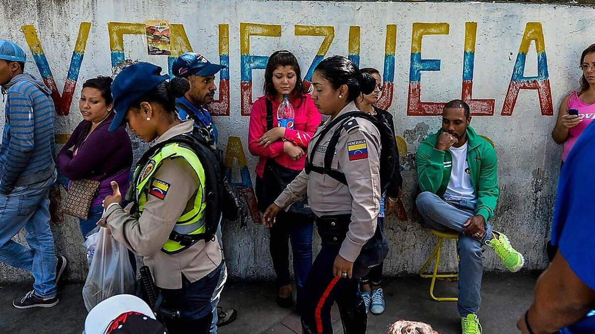 Im langen Schlangen stellen sich Venezolaner für Lebensmittel an.