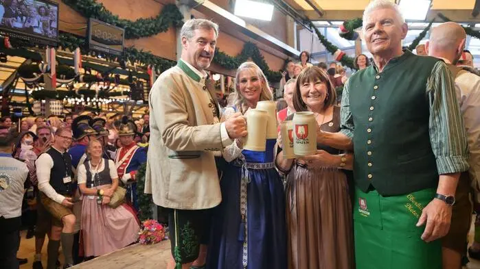 Markus Söder (CSU), Ministerpräsident von Bayern, mit seiner Frau Karin Baumüller-Söder, und Dieter Reiter (SPD), Oberbürgermeister von München, mit seiner Frau Petra,  nach dem Bieranstich um Punkt 12 Uhr.