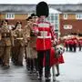 3 year-old Irish Wolfhound Seamus, Irish Guards mascot, with his handler Drummer Ashley Dean march following the Irish Guards Parade for St Patrick's Day at Mons Barracks in Aldershot, south-west of London, on March 17, 2024. (Photo by HENRY NICHOLLS / AFP)