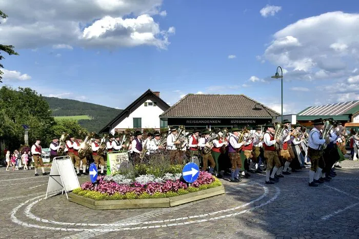 Ein malerisches Bild boten die Musiker und Musikerinnen in ihren bunten Gewändern vor dem Hintergrund der Wallfahrtskirche Pöllauberg