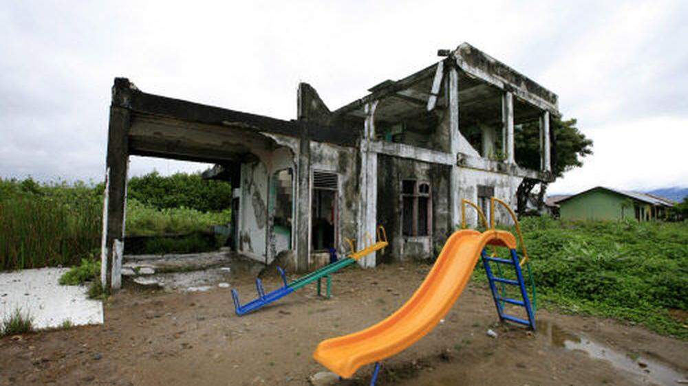 10 Jahre nach der Katastrophe: Kinderspielplatz vor einem zerstörten Haus