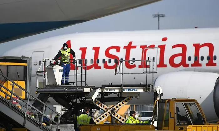 ABD0142_20200330 - SCHWECHAT - ÖSTERREICH: ZU APA0523 VOM 30.3.2020 - Mitarbeiter des Flughafens beim Entladen von Schutzausrüstung am Montag, 30. März 2020, am Flughafen Wien-Schwechat. Die Austrian Airlines haben mit zwei zu Frachtflugzeugen umfunktionierten Boeing 777 weitere 30 Tonnen Schutzausrüstung aus China nach Österreich geflogen. Es handelte sich um knapp zwölf Tonnen Masken und knapp 18 Tonnen Mäntel. - FOTO: APA/HELMUT FOHRINGER