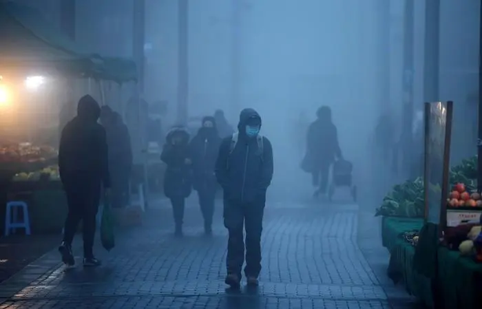 (FILES) Pedestrians, some wearing a face mask or covering due to the COVID-19 pandemic, walk in the early morning fog in Walthamstow, east London on November 27, 2020. The number of people not working in the UK due to chronic illnesses has soared since the pandemic, putting pressure on the British economy, analysts said on August 15, 2023. The proportion of the population in the labour market peaked in early 2020 but 