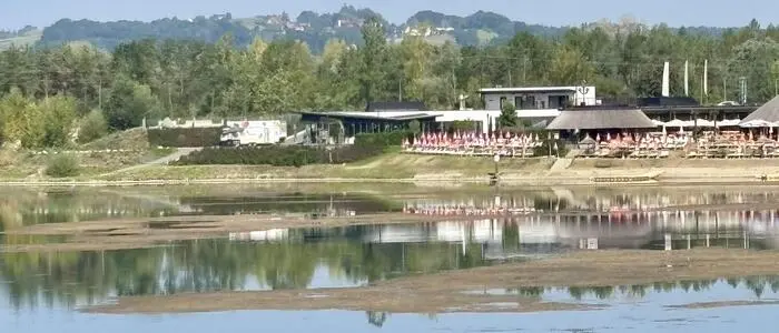 Blick über den Aldriansee zum Restaurant- und Veranstaltungsbetrieb „Ankerpunkt“ am gegenüberliegenden Ufer. Hier wird der heuer stark abgesunkene Wasserstand besonders deutlich