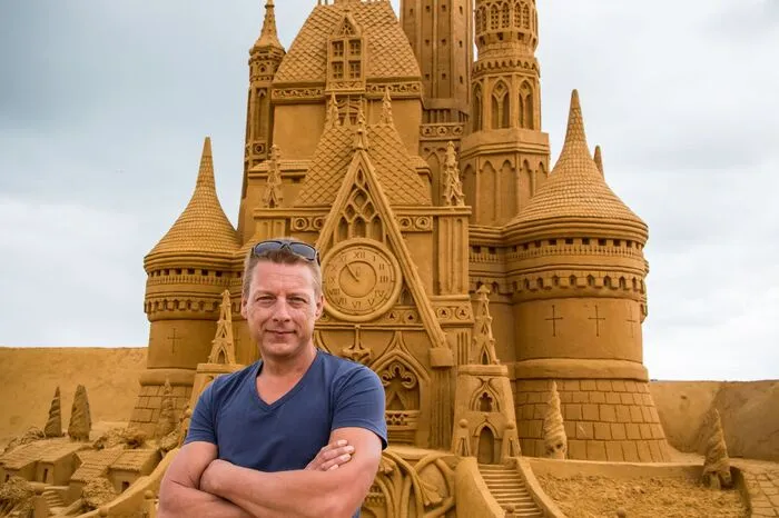 Organisator Alexander Deman posiert vor dem Disney-Schloss, insgesamt werden 150 Sandskulpturen gezeigt.
