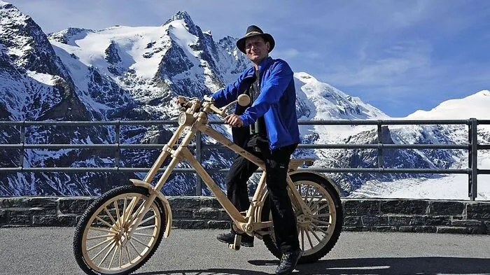 Georg Granig mit seinem Fahrrad aus drei Hölzern. Im Hintergrund der Großglockner