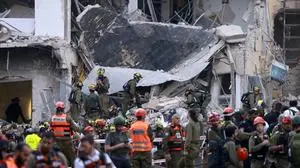 Rescuers sift through the debris of a damaged building in the Israeli city of Tel Aviv after a fresh barrage of Iranian rockets on June 16, 2025. The Israeli military said early on June 16 that it was striking surface-to-surface missile sites in Iran, its latest move in three days of escalating conflict between the rival states. "The IDF is currently striking surface-to-surface missile sites in central Iran," Israel Defense Forces (IDF) spokesman Nadav Shoshani wrote on X. "We are operating against this threat in our skies and in Iranian skies." (Photo by Menahem Kahana / AFP)