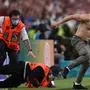 A fan runs past stewards onto the pitch during the UEFA EURO 2020 final football match between Italy and England at the Wembley Stadium in London on July 11, 2021. (Photo by Laurence Griffiths / POOL / AFP)