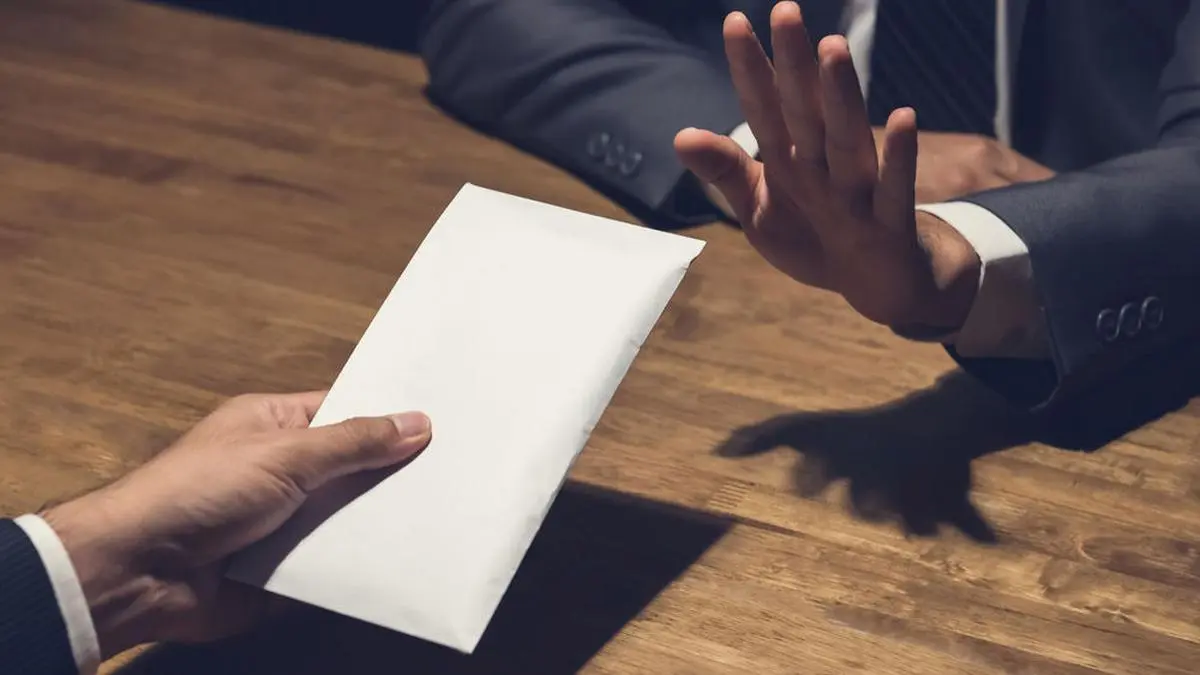 Businessman rejecting money in white envelope offered by his partner in the dark, anti bribery concept - panoramic banner