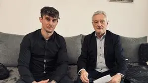 Zwei Männer sitzen auf einer Couch und schauen in die Kamera