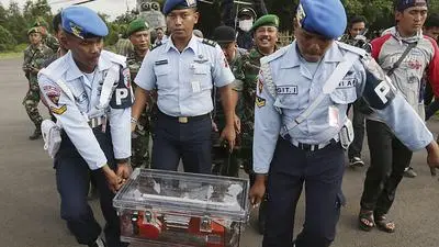 Indonesian air force personnel carry the flight data recorder of the ill-fated AirAsia Flight 8501 that crashed in the Java Sea, at the airport in Pangkalan Bun, Indonesia, Monday, Jan. 12, 2015. Divers retrieved one black box Monday and located the other from the AirAsia plane that crashed more than two weeks ago, a key development that should help investigators unravel what caused the aircraft to plummet into the Java Sea. (AP Photo/Achmad Ibrahim)