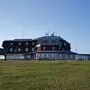 Blick auf Gipfelhaus auf der Gerlitzen, im Vordergrund sieht man eine Wiese, dahinter erstreckt sich das Gebäude