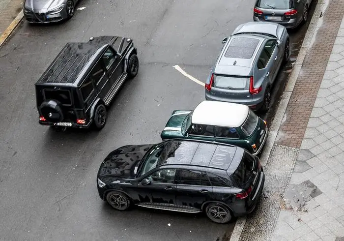 Download von www.picturedesk.com am 05.02.2024 (12:45). 
Rover Mini Cooper 1.3i mit Ralleystreifen, eingeklemmt zwischen Mercedes Benz SUV und Volvo XC 40 SUV, David gegen Goliath in der City. Konkurrenz, Konkurrent, konkurrent, Stadt, staedtisch, innerstaedtisch, Sport Utility Vehicle, Wagen, Gelaendewagen, sportive, sportlich, Auto, PKW, mobil, Mobilitaet, Verkehr, Strasse, Strassenverkehr, Parkplatz, Buergersteig, KFZ, Kraftfahrzeug, Riese, riesig, Zwerg, klein, Verkehrswende. Berlin Schoeneberg. 20. Februar 2022.Engl a small Rover Mini Cooper 1.3i, jammed between Mercedes Benz SUV and Sport Utility Vehicle Volvo XC 40 parking on public area along pavement. all terrain, cross country, offroad, off, road, sportive, mobile, mobility, traffic, car, park, place, giant, dwarf. Berlin, Germany. 20th of February 2022 - 20220220_PD22822 - Rechteinfo: Rights Managed (RM) Achtung Mindestpreis - nicht zum Listenpreis erhältlich Nur für redaktionelle Nutzung!