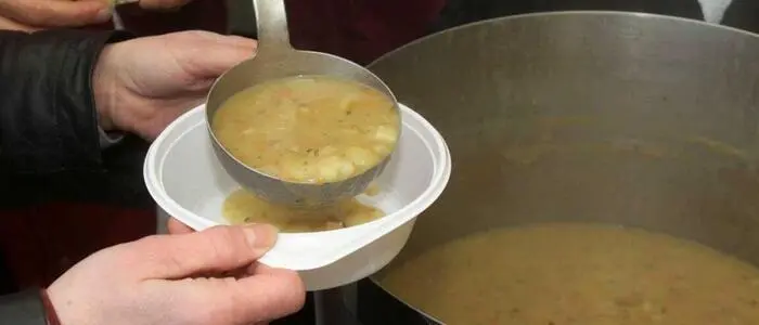 Aus einem großen Topf wird Suppe geschöpft