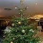 Ein prunkvoll geschmückter Christbaum steht mittig auf dem Foto, im Hintergrund sieht man leicht verschwommen Leute beim Feiern | Weihnachtsfeiern abzuschaffen ist für die Gemeinden im Bezirk kein Thema