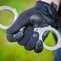 Ein Polizist hält Handschellen bereit | Der Mann wurde festgenommen
