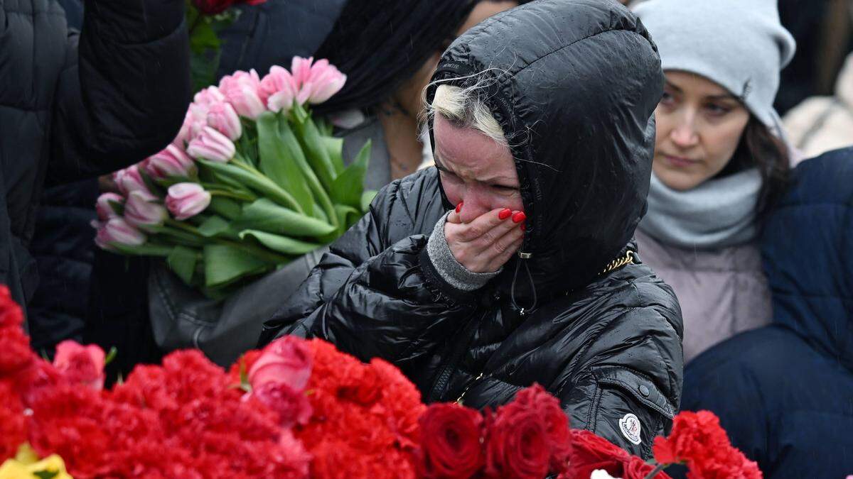 Menschen trauern an einer behelfsmäßigen Gedenkstätte zum Gedenken an die Opfer des Terroranschlags vom 22. März auf das Konzerthaus Crocus City Hall bei Moskau