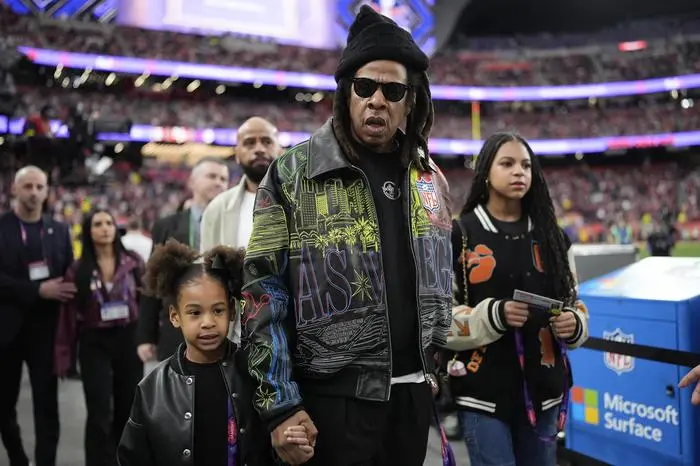 Rumi Carter, from left, Jay-Z, Blue Ivy Carter walks on the sidelines before the NFL Super Bowl 58 football game between the San Francisco 49ers and the Kansas City Chiefs, Sunday, Feb. 11, 2024, in Las Vegas. (AP Photo/George Walker IV)