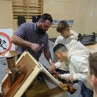 Anton Matlas zeigt vor, wie's geht: Die Schüler durften selbst Dachziegel decken