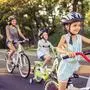 Happy family is riding bikes outdoors and smiling. Little girl in the foreground