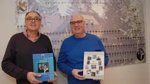 Die Brüder Heimo Haury (l.) und Anton Korb (r.) mit der Familienchronik vor dem Familienstammbaum
