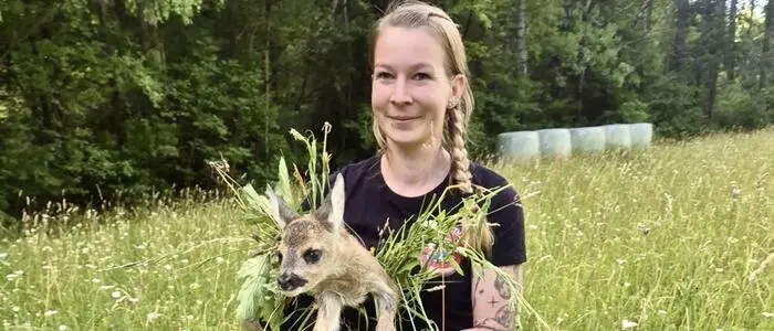 Eine Frau mit einem Rehkitz in der Hand