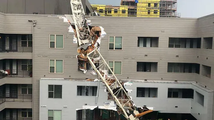 Ein schwerer Sturm, in dessen Folge ein Kran auf ein Gebäude gestürzt ist, hat mindestens ein Menschenleben gekostet.