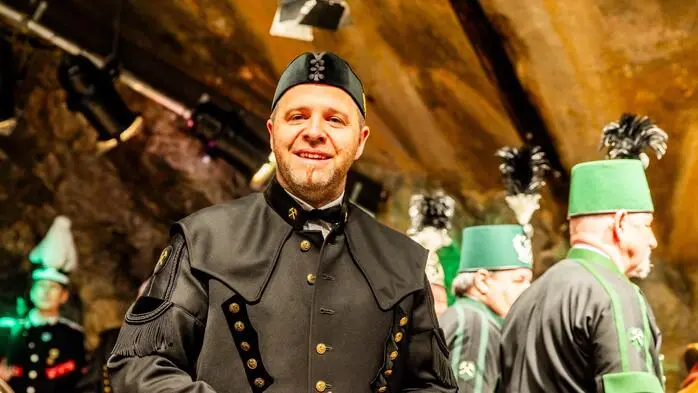 Ein Mann in Bergmannskluft lächelt in die Kamera