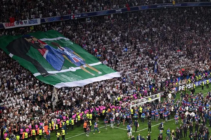 TOPSHOT - Paris Saint-Germain fans display a banner in the tribunes depicting Paris Saint-Germain's Spanish head coach Luis Enrique planting a flag for his late daughter Xana after the UEFA Champions League final football match between Paris Saint-Germain (PSG) and Inter Milan in Munich, southern Germany on May 31, 2025. (Photo by Kirill KUDRYAVTSEV / AFP)