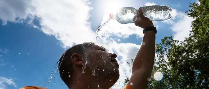 Ein Mann schüttet sich aufgrund der Hitze eine Flasche Wasser übers Gesicht