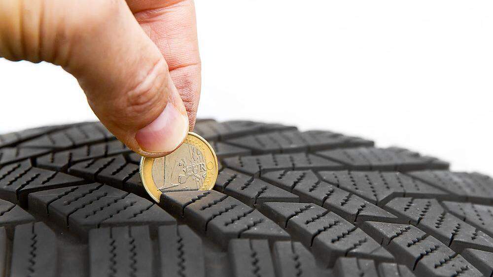 Eine 1-Euro-Münze hilft beim Messen des Reifenprofils 