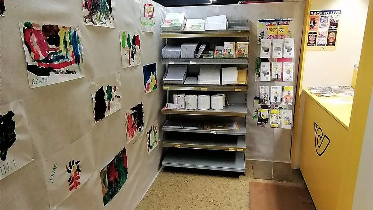 Derzeit trennt diese provisorisch aufgestellte Wand mit Bildern von Kindergartenkindern die Post und den Lebensmittelbereich
