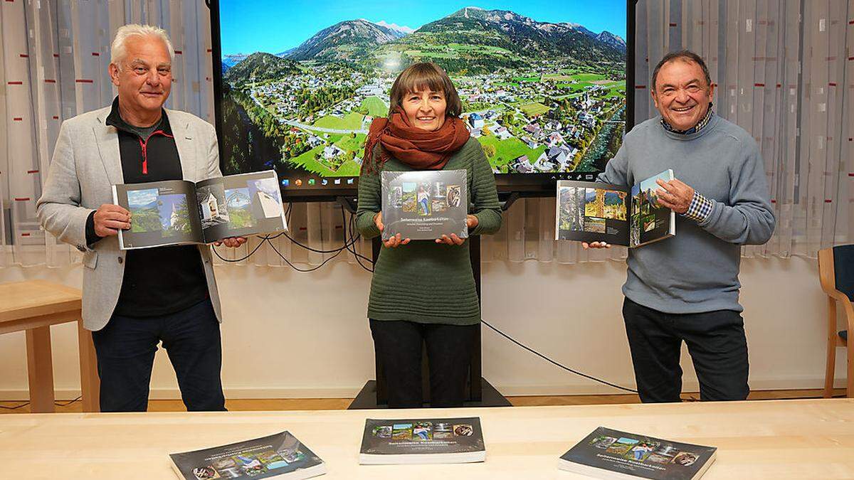 Bürgermeister Kurt Felicetti, Autorin Ulrike Mengeú, Fotograf Reinhard Kager mit ihrem Buch „Seitenweise Kostenbarkeiten zwischen Danielsberg und Drauknie“