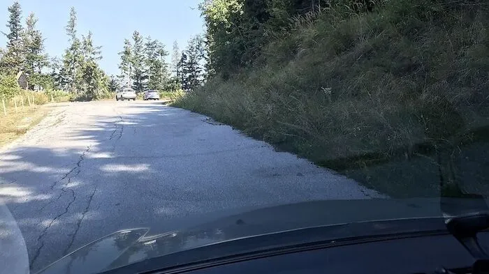 Parken ist auf der dem Berg zugewandten Seite erlaubt (hier rechts). Die beiden Autos im Hintergrund parken falsch
