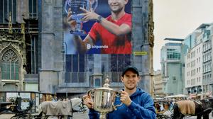 Dominic Thiem vor seinem Plakat am Wiener Stephansdom mit dem Siegerpokal der US Open