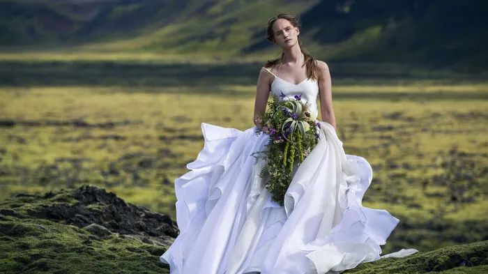 In Eva Poleschinskis Brautmoden-Kollektion „Bridal and Eve“, dieauf der Insel von Eis und Feuer, in Island, fotografiert wurde, spielen auf alle Fälle Federn und Tüll eine tragende Rolle. Sie zieren üppigst Röcke, aber auch zierliche Brautschultern oder Rocksäume.