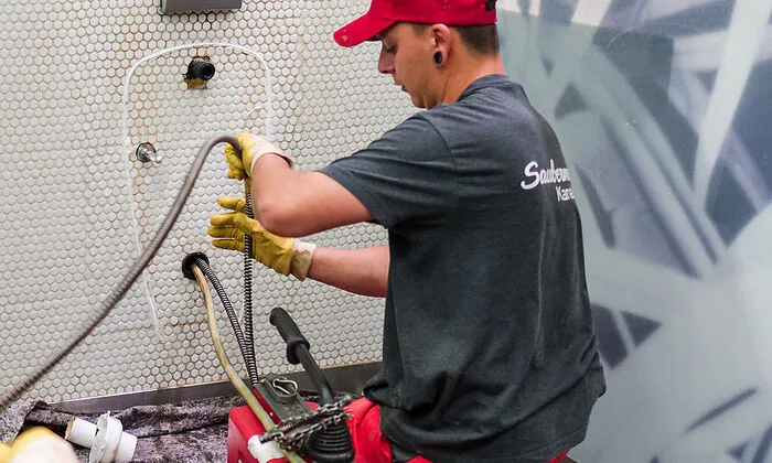 Saubermacher-Mitarbeiter Kevin Liendl löst eine Pissoir-Verstopfung mit Hilfe einer mechanischen Rohrreinigungsmaschine