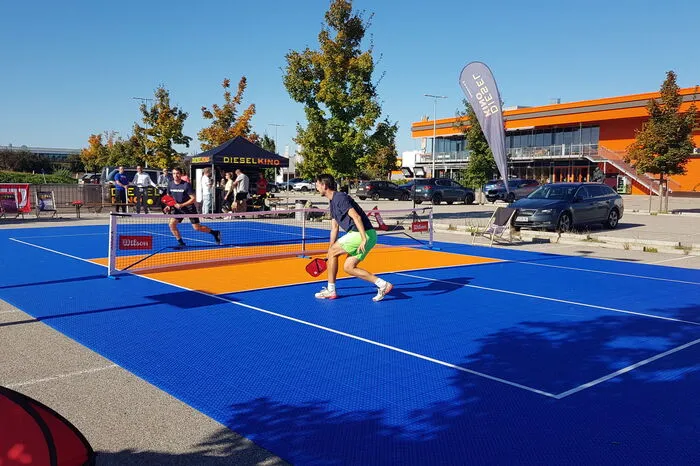 Dort kann im gesamten Oktober der neue Trendsport ausprobiert werden. Dabei handelt es sich wie beim Padel Tennis um eine weitere Abwandlung von Tennis. Gespielt wird auf einem kleinen Feld mit Tischtennis-ähnlichen Carbonschlägern und einem Plastikball mit Löchern.