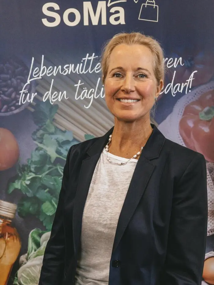 Eine Frau mit Sakko lächelt in die Kamera