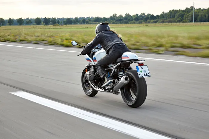 Also, schauen wir uns das näher an: Bewusste Reminiszenzen an Sportmotorräder der frühen 1970er-Jahre weckt die R nineT Racer. Mit ihrer betont knapp geschnittenen Halbschalenverkleidung, der Höckersitzbank, dem Stummellenker und den zurückverlegten Fußrasten strahlt sie den Charme eines Bikes der alten Schule aus und kombiniert ihn mit moderner Technik.
