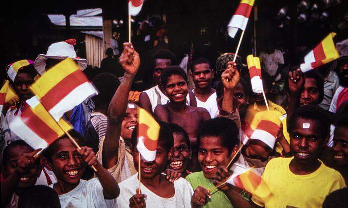 Einer von vielen ironischen Akzenten der Schau: Fahnenschwingende Schüler in Papua-Neuguinea, fotografiert von  Helmut Aichinger 