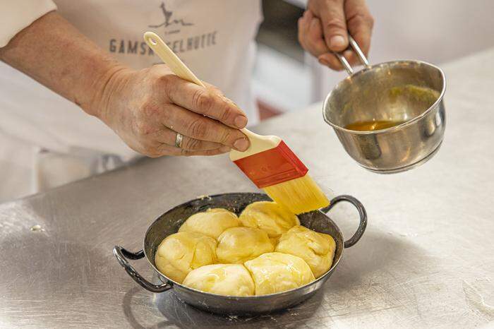 Bevor die Buchteln in den Ofen kommen, mit reichlich zerlassener Butter bestreichen