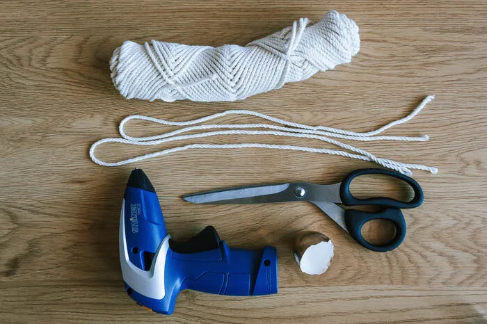 leere Eierschalen Baumwollgarn oder dekoratives Band (2x ca. 60cm pro Eierschale)SchereHeißklebepistole
