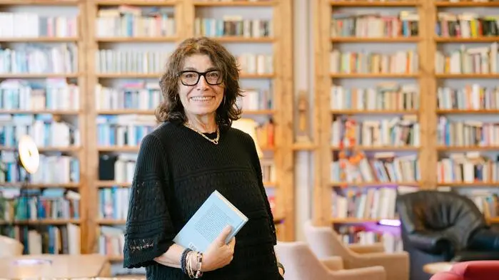 Anita Keiper vor der XXL-Bücherwand am Verlagsstandort in der Grazer Puchstraße. Im „Literaturwohnzimmer“ finden auch Veranstaltungen statt