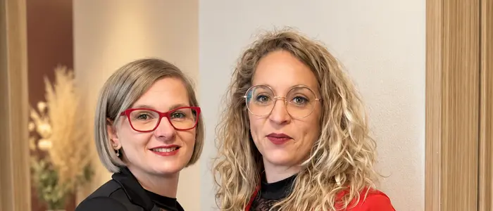 Zwei Frauen stehen in einem Türrahmen