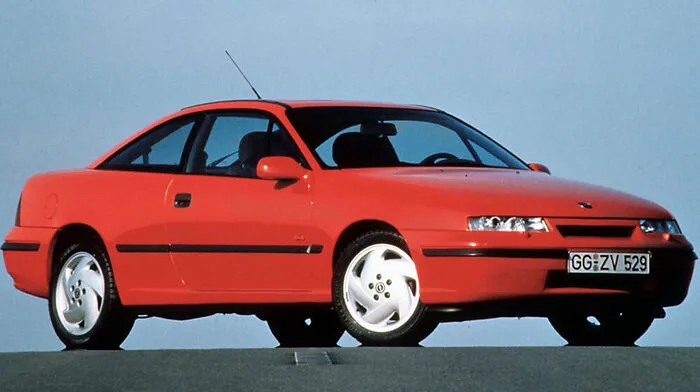 Die Rüsselsheimer wurden nicht müde zu betonen, dass der Opel Calibra keinesfalls die Nachfolge des legendären Manta antreten sollte. Eine Welle an neuen Witzen wollte man partout nicht heraufbeschwören. Als Steffi Graf im Herbst 1989 auf der IAA das Tuch vom Coupé zog, rauschte es dennoch nur so vor Vergleichen im Blätterwald. Aber der Calibra beschritt technisch ganz andere Wege: Seine Motoren waren quer eingebaut und trieben die Vorderachse an. Aber Erhard Schnells Design für den 2+2 mit riesiger Heckklappe zog und brachte ihm mit einem Luftwiderstandsbeiwert von 0,26 damals den Titel des Aerodynamikweltmeisters ein. Dass die Leuchteinheiten im Gesicht nur sieben Zentimeter flach waren, erreichten die Techniker durch den Einsatz von Ellipsoid-Scheinwerfern. Ja, Opel war ehrgeizig - und deshalb sollte mit den 2-Liter-Vierzylindern im Angebot auch nicht Schluss sein.