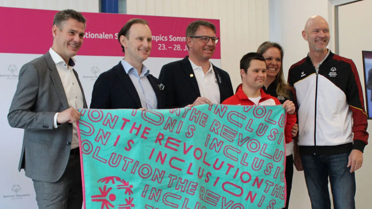 Vertreter von Vossen (Marc Thamm und Paul Mohr ganz links) und der Special Olympics mit einem Athleten und dem Duschhandtuch